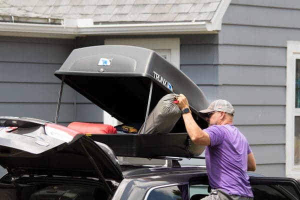 Man filling up an 18 cu ft carrier with camping equipment